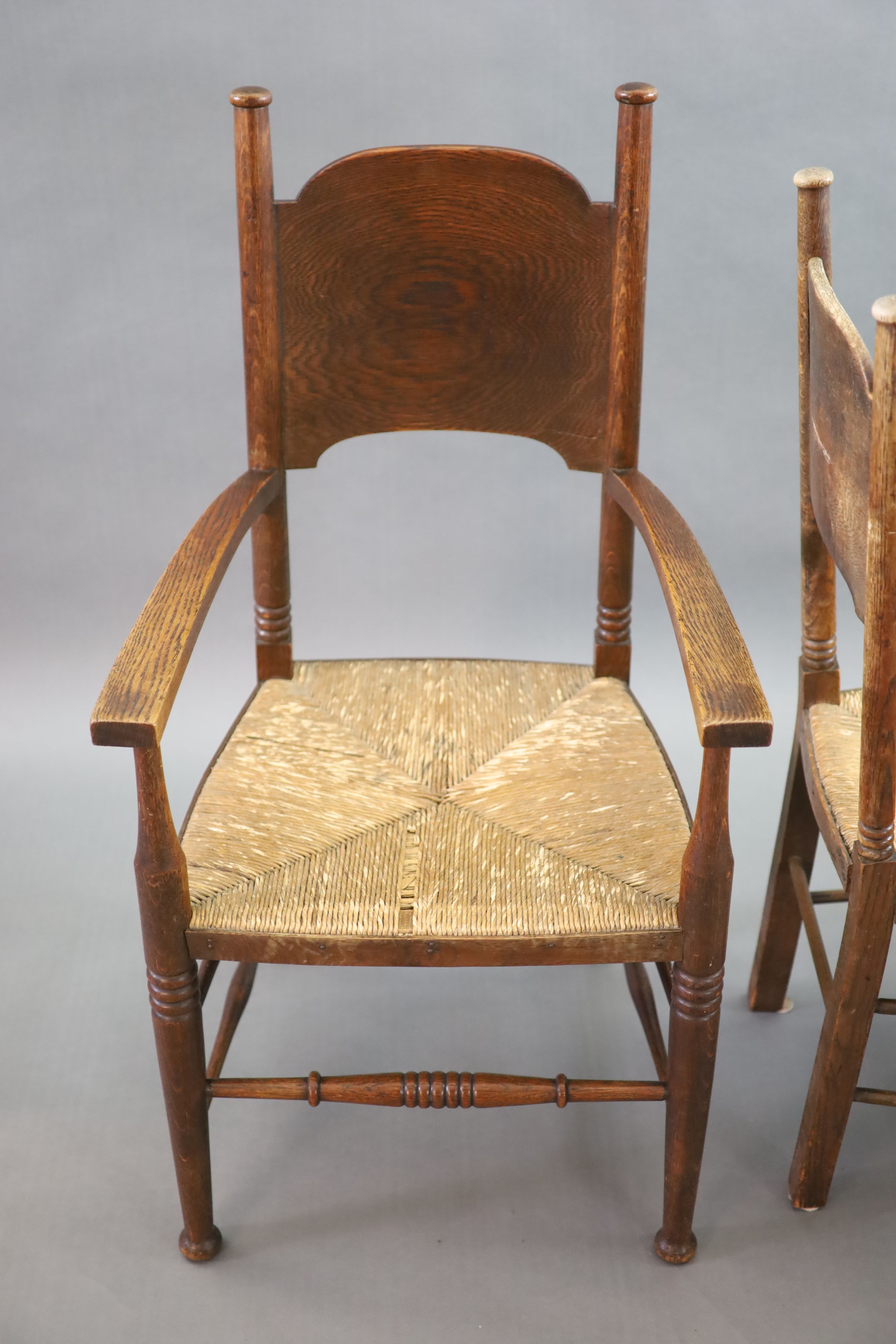 A set of six Arts & Crafts oak chairs, including a pair of carvers, in the Glasgow School manner by William Birch, High Wycombe, carvers W.58cm D.54cm H.109cm